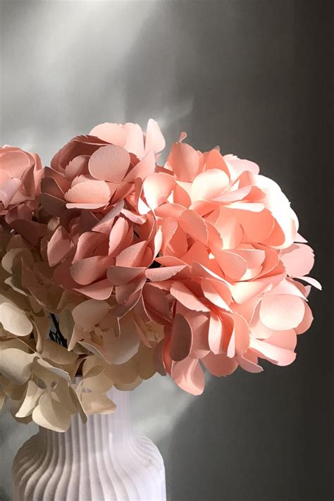 Mise en scène d'une branche d'hortensia en papier sous un éclairage tamisé