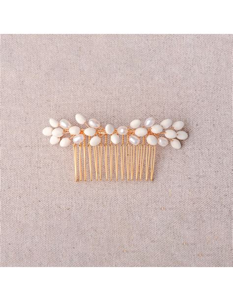 Détail rapproché d'un peigne de mariée avec perles et fleurs en argile