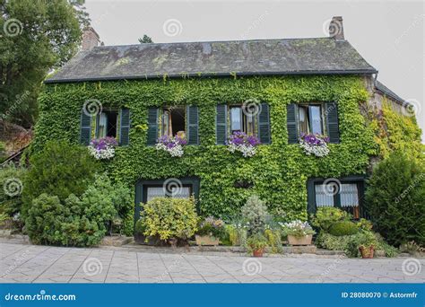 une maison ancienne couverte de lierre en façade