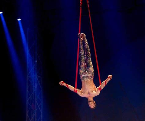 Artiste de cirque réalisant une figure de sangles aériennes