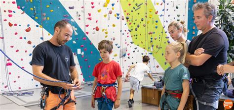 Moniteur d'escalade accompagnant un groupe d'enfants sur une falaise