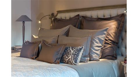 Photographie d'une chambre à coucher lumineuse présentant une parure de lit coordonnée aux motifs floraux