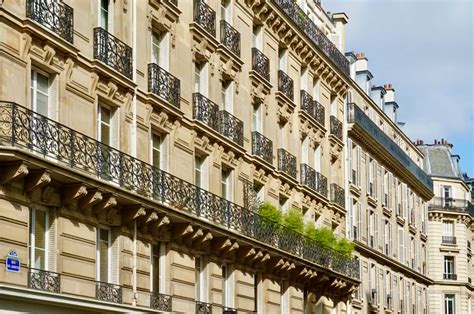 Vue d'ensemble d'une façade haussmannienne typique avec ses balcons filants et ses ornements en pierre de taille