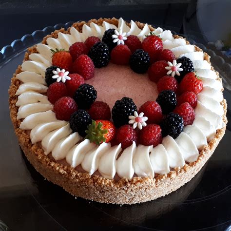 gâteau décoré avec des fleurs comestibles et des fruits rouges