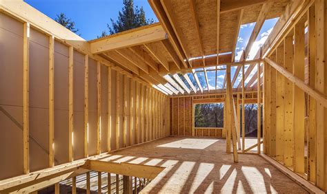 Chantier de construction d'un bâtiment, ossature en bois et soubassements en pierre