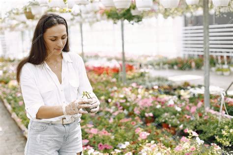 une femme jardinière souriante tenant une petite plante