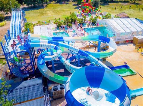 Enfants s'amusant dans la piscine et le toboggan aquatique du camping