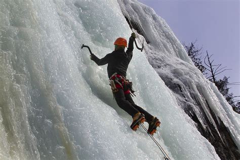 Guide d'escalade en pleine ascension sur paroi rocheuse