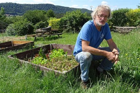 Didier Helmstetter dans son jardin en train d'appliquer la technique du paillage au foin