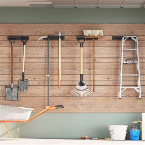 Espace de rangement organisé avec supports muraux pour outils de jardin