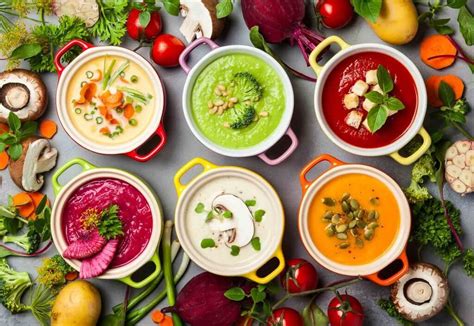 une sélection de bols de soupes colorées et variées sur une table en bois