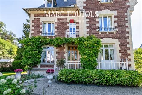 Image illustrant une façade de demeure bourgeoise rénovée avec un jardin arboré