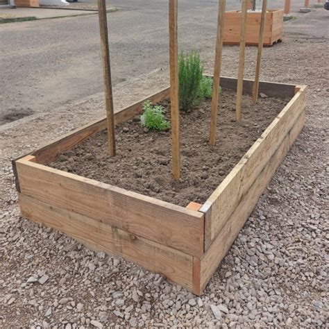 Photo d'un jardinier installant les planches d'un carré potager