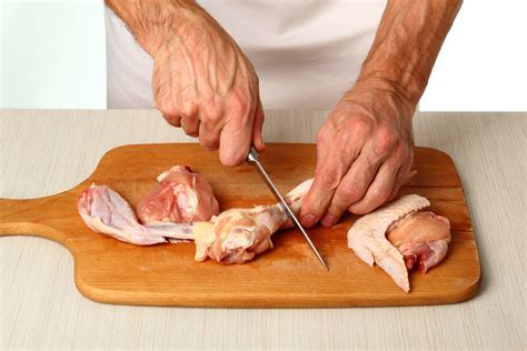 Sécateur à volaille en action coupant un poulet cru