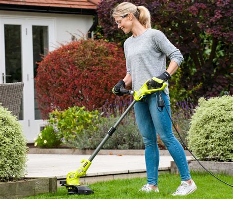 Un jardinier utilisant un coupe-bordure à batterie pour des finitions précises