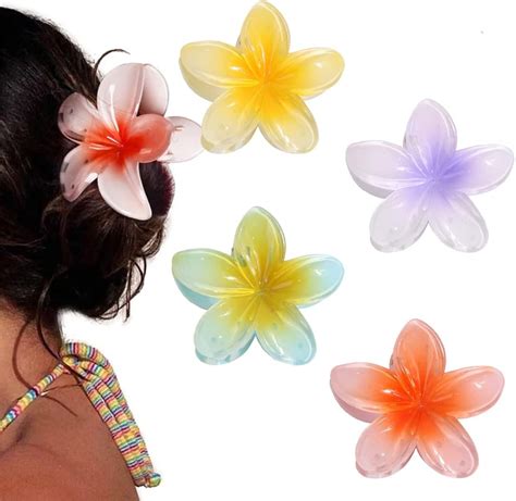 une femme portant une pince à cheveux fleur hibiscus sur une plage au coucher du soleil
