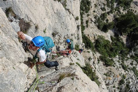 Grimpeur redescendant en rappel d'une grande voie