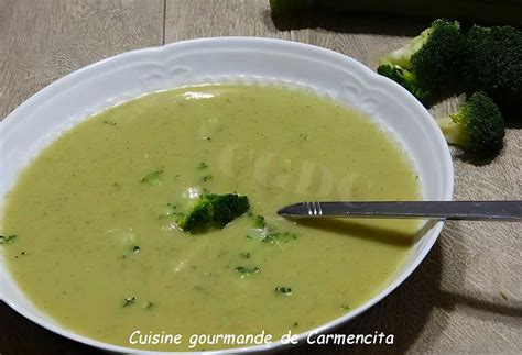 une assiette de velouté de brocoli fumant, décorée de quelques fleurons de brocoli et d'un filet de crème