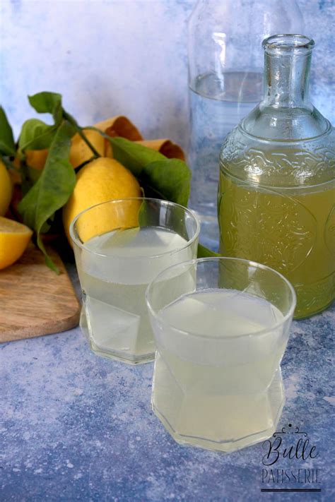 Une petite casserole contenant un sirop transparent, avec des zestes de citron vert flottant à la surface.