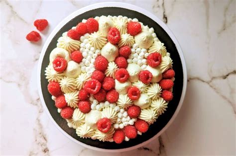 Un entremets framboisier joliment décoré avec une ganache montée pochée en forme de fleurs.