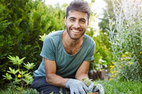 Portrait d'un jardinier souriant avec des gants et des outils