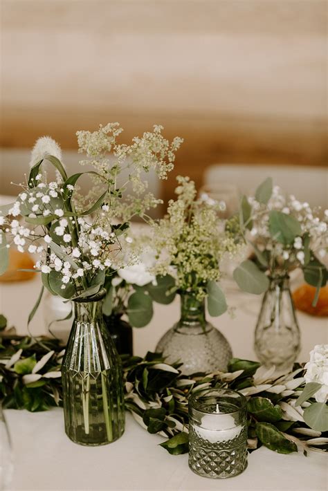Composition de table de mariage intégrant du lierre artificiel et des bougies