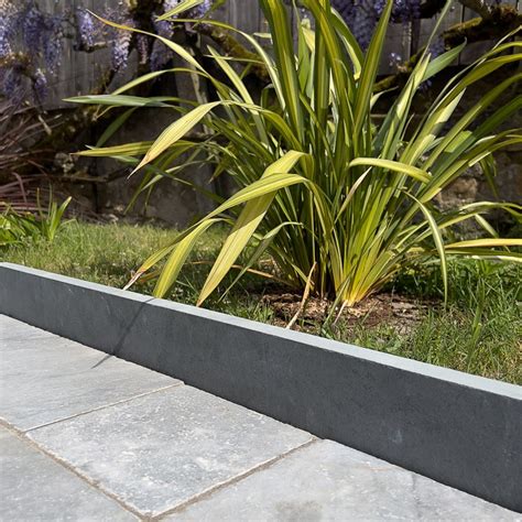 Détail photographique d'une bordure en ardoise sciée installée le long d'une allée