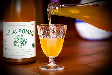 Illustration d'une bouteille de jus de pomme artisanal à côté d'un panier de fruits frais