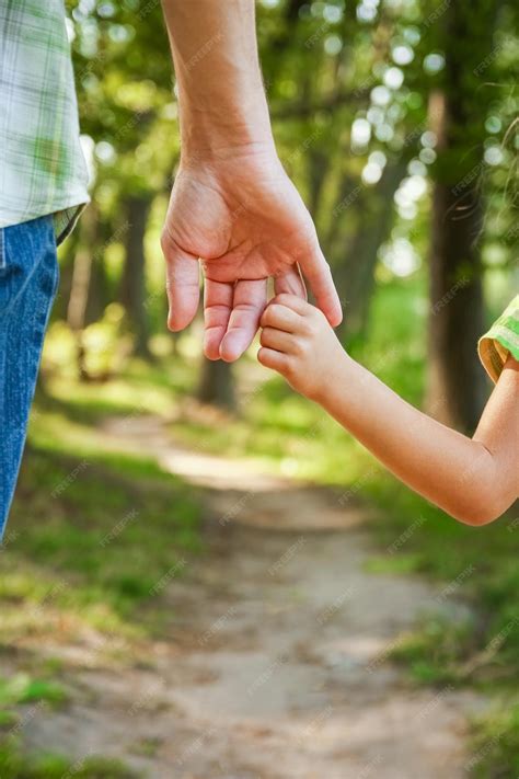 Une famille se tenant la main, vue de dos, regardant l'horizon