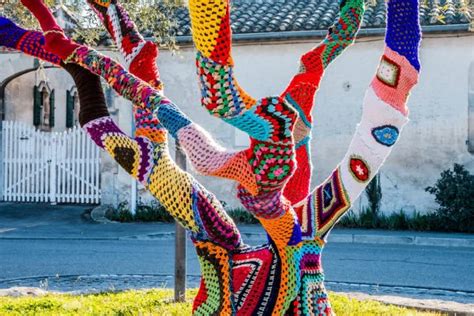 Une installation colorée de tricot urbain sur un arbre en milieu citadin