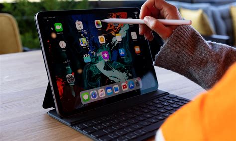 une personne utilisant une tablette numérique dans un jardin potager ensoleillé pour planifier ses plantations