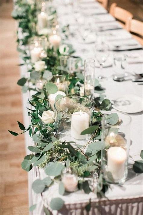 Chemin de table végétal composé de feuillages de lierre et eucalyptus
