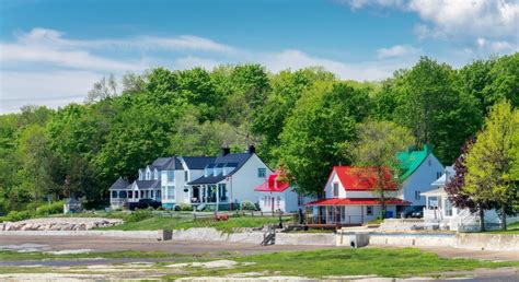 Scène panoramique de l'Île d'Orléans avec un verger au premier plan et le pont en arrière-plan