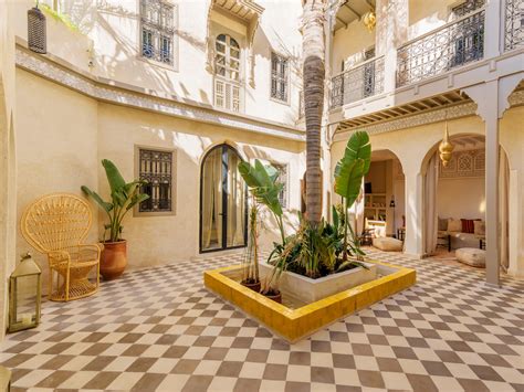 Vue intérieure d'un patio traditionnel de riad à Marrakech avec bassin et végétation luxuriante