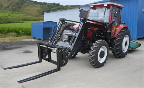 Tracteur de 40 chevaux équipé d'une fourche à fumier en plein travail dans une exploitation agricole