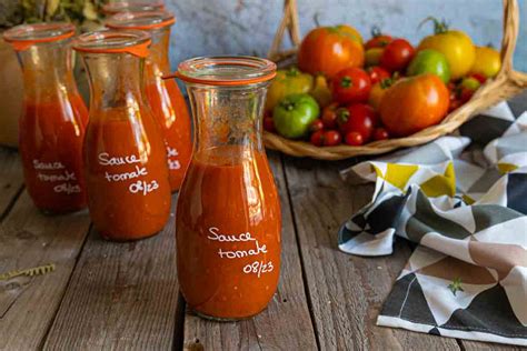 rangée de bocaux en verre remplis de sauce tomate maison sur une étagère