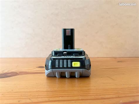 Gros plan sur une batterie RYOBI 18V avec son indicateur de charge
