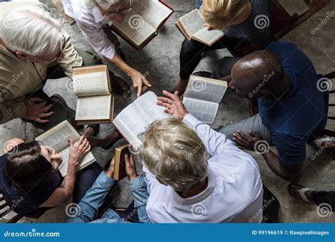 Personnes de cultures diverses lisant la Bible ensemble