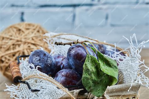 Panier de prunes fraîches sur une table de jardin