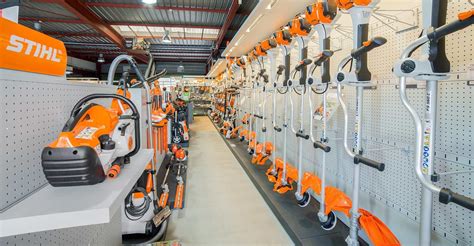 une sélection de débroussailleuses thermiques modernes alignées dans un entrepôt de location
