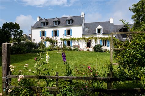 Vue extérieure d'une maison traditionnelle bretonne entourée d'hortensias en fleurs