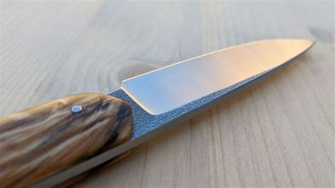 Atelier de coutellerie traditionnelle avec établis en bois et outils manuels