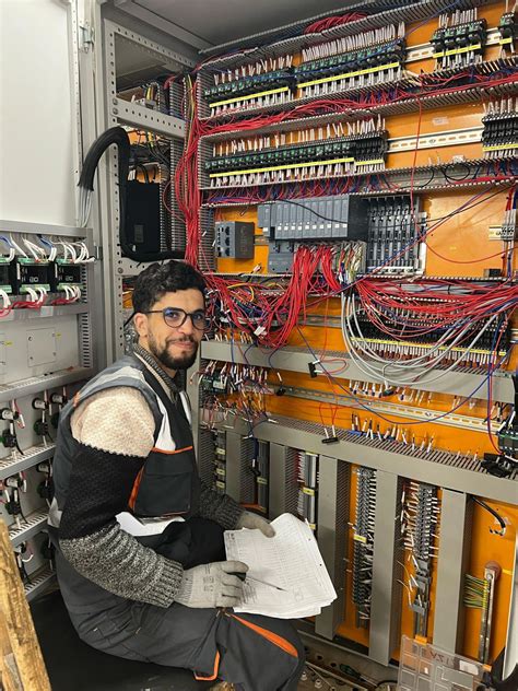 Technicien procédant au câblage interne d'une armoire de commande