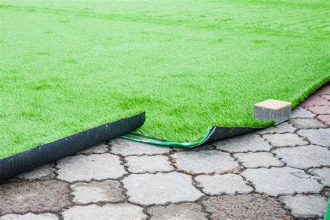 Installation de gazon synthétique sur une terrasse moderne avec mobilier extérieur