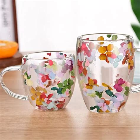 infusion d'hibiscus dans une tasse en verre avec des fleurs séchées à côté