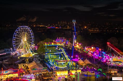 Ambiance nocturne de la Foire du Trône sur la Pelouse de Reuilly avec les manèges illuminés