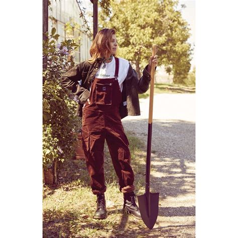 Femme portant une salopette de jardinage, travaillant dans un jardin fleuri