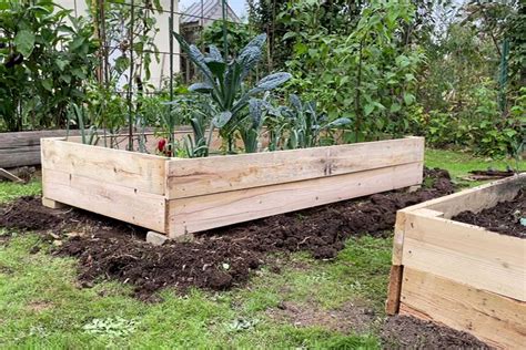Photo d'un bac potager en bois avec des arceaux galvanisés installés