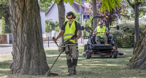 Agent d'entretien d'espaces verts utilisant une débroussailleuse