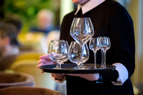 Un plateau de service avec plusieurs verres de thé glacé, chacun garni différemment avec des baies, des agrumes et des herbes aromatiques.